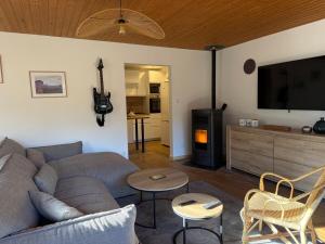 a living room with a couch and a flat screen tv at Chalet dans la nature in Palisse
