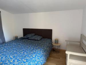 a bedroom with a bed with a blue comforter at Chalet dans la nature in Palisse