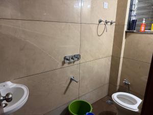 a bathroom with a sink and a toilet at Harmony Palace Guest House in Nashik