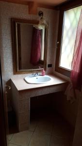 łazienka z umywalką, lustrem i oknem w obiekcie Michela w mieście Monteforte dʼAlpone