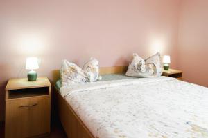 a bedroom with a bed with white sheets and pillows at Casa Dorin Capacitate Autocar in Borşa