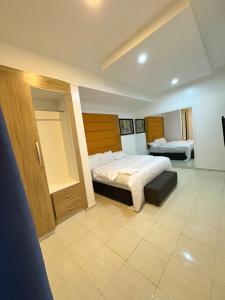 a hotel room with a bed and a room with two beds at Modern 3BR in Lekki Phase 1 in Lekki