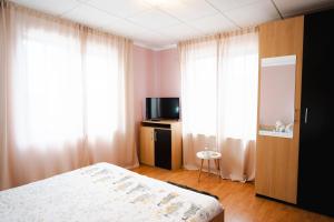 a bedroom with a bed and a television and curtains at Casa Dorin Capacitate Autocar in Borşa