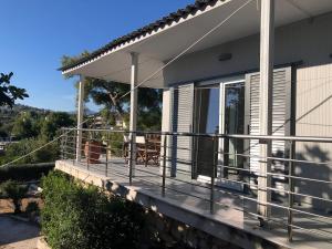 a house with a balcony with a view of the ocean at Lagonisi Cottage - with spacious garden in Áyios Nikólaos