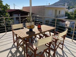 a wooden table and chairs on a balcony at Lagonisi Cottage - with spacious garden in Áyios Nikólaos