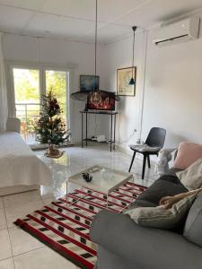 a living room with a couch and a christmas tree at Lagonisi Cottage - with spacious garden in Áyios Nikólaos