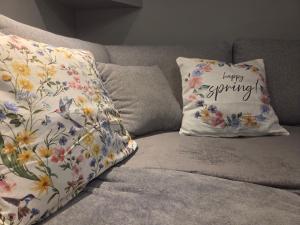 a pillow with a happy spring written on it on a couch at Apartament KARO in Zawiercie