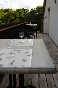 a table with two wine glasses on top of a deck at Cosy Eco-Loft in Pettingen +19 photos