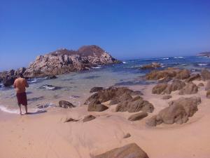 a man standing on a beach with rocks at Casa de ámbar cuatunalco in Cuatunalco +8 photos