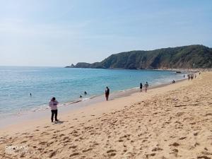 a group of people walking on the beach at Casa de ámbar cuatunalco in Cuatunalco
