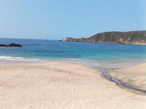 a sandy beach with the ocean in the background at Casa de ámbar cuatunalco in Cuatunalco