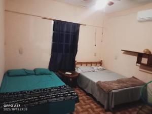 two beds in a small room with a window at Casa de ámbar cuatunalco in Cuatunalco