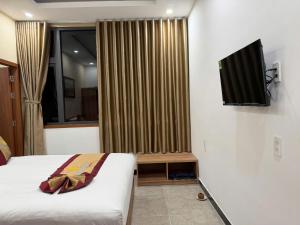 a bedroom with a bed and a television on the wall at Minh Minh Nam 3 Hotel in Can Tho