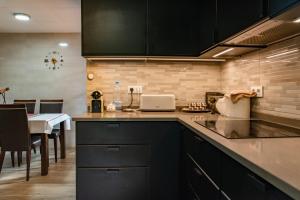 a kitchen with black cabinets and a table with a laptop at Villa Ficus in Lloret de Mar