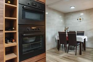 a kitchen with an oven and a table with chairs at Villa Ficus in Lloret de Mar