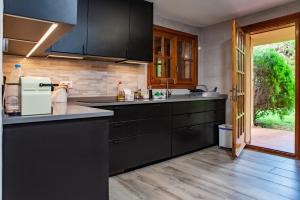 a kitchen with black cabinets and a wooden floor at Villa Ficus in Lloret de Mar