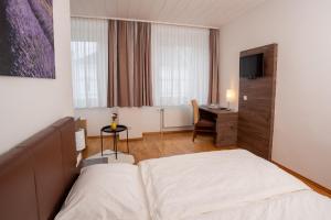 a hotel room with a bed and a desk at Lemon Living Self-Check-in in Ottensheim