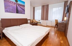 a bedroom with a large white bed in a room at Lemon Living Self-Check-in in Ottensheim +3 photos