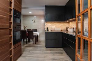 a kitchen with black cabinets and a dining room at Villa Ficus in Lloret de Mar