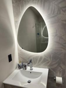 a bathroom with a white sink and a mirror at Adagio Quito Suite de Lujo in Quito +30 photos