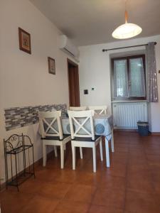 a dining room with white chairs and a table at L'Antica Corte in Mongardino