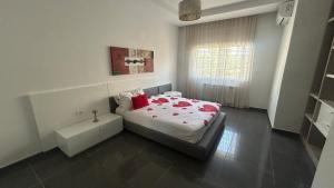 a bedroom with a bed with red pillows on it at Da Dora in Dar el Haj Ahmed Souid