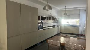 a kitchen with white cabinets and a table and chairs at Da Dora in Dar el Haj Ahmed Souid