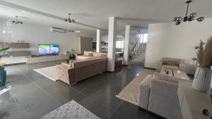 a living room with two couches and a tv at Da Dora in Dar el Haj Ahmed Souid