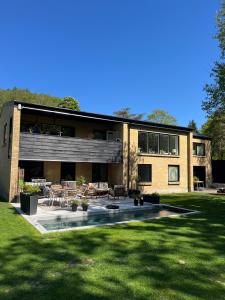a large house with a patio and a yard at Winding B&B Silkeborg in Silkeborg