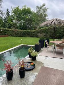 a swimming pool with a table and chairs and a table and a patio at Winding B&B Silkeborg in Silkeborg