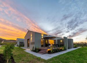 a house with a sunset in the background at LEO Sky Farm Cottages in Simondium