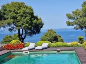 a swimming pool in a garden with pillows and flowers at Villa Musa with private pool in Afitos