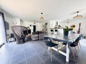 a kitchen and living room with a table and chairs at L'Écrin d'Ussat in Ussat