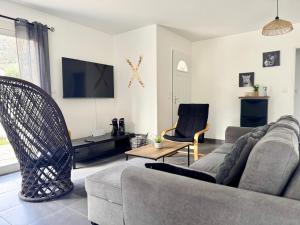 a living room with a couch and a tv at L'Écrin d'Ussat in Ussat