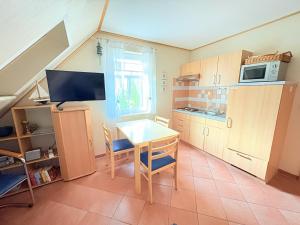 a small kitchen with a table and a microwave at Ferienwohnung Flieder - ruhig und tierfreundlich in Mariendorf