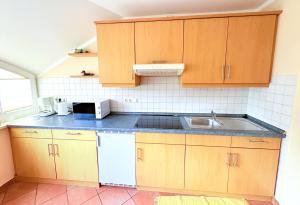 a kitchen with wooden cabinets and a sink at Fewo Lavendel - mit Dachterrasse, Hund ist willkommen in Mariendorf +13 photos