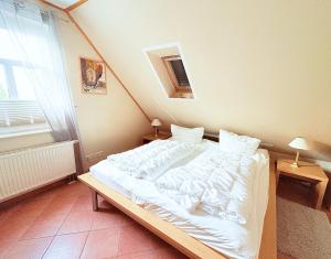 a bedroom with a white bed in a room at Ferienwohnung Flieder - ruhig und tierfreundlich in Mariendorf