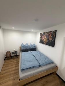 a bedroom with a bed with blue sheets on it at Zauberhafte Erdgeschoss-Maisonettewohnung in Bovenden