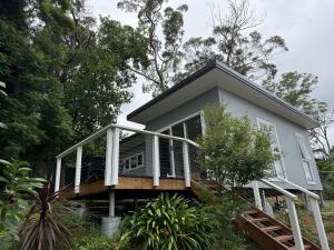 a tiny house with a porch and a balcony at Cosy Granny flat in Epping in Epping