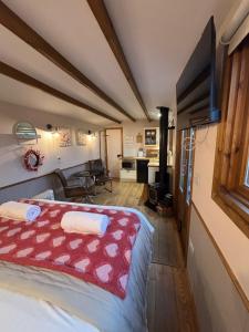 a bedroom with a bed with a red blanket at Hafod Shepherd Hut in Aberystwyth