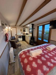 a bedroom with a bed with a red and white blanket at Hafod Shepherd Hut in Aberystwyth
