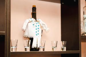 a bottle of wine on a shelf with glasses at Casa Dorin Capacitate Autocar in Borşa