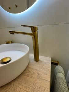 a bathroom sink with a gold faucet on a counter at SuitePoolBarcelona in Vilassar de Dalt +18 photos