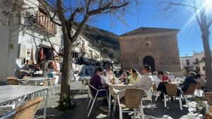a group of people sitting at tables in an alley at Casa Walhalla & Cortijo El Páramo in Pampaneira