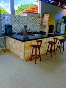a kitchen with a counter with stools in front of it at Bio natura in Marechal Deodoro +3 photos
