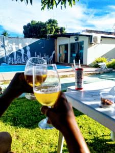a person holding a glass of wine at a table at Bio natura in Marechal Deodoro