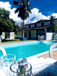 a pool with a table and chairs and a palm tree at Bio natura in Marechal Deodoro