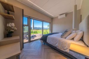 a bedroom with a bed and a large window at LEO Sky Farm Cottages in Simondium +50 photos