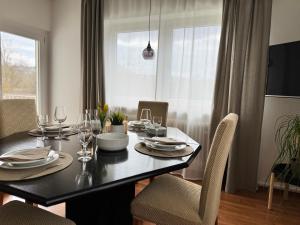 a dining room with a table with chairs and a window at FeWo Pelkmann Apartment 1 - Die Grüne Oase - Garten & Terrasse in Weikersheim