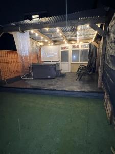 a room with a stage with chairs and a screen at Intimate Hot Tub Pad in Swanscombe